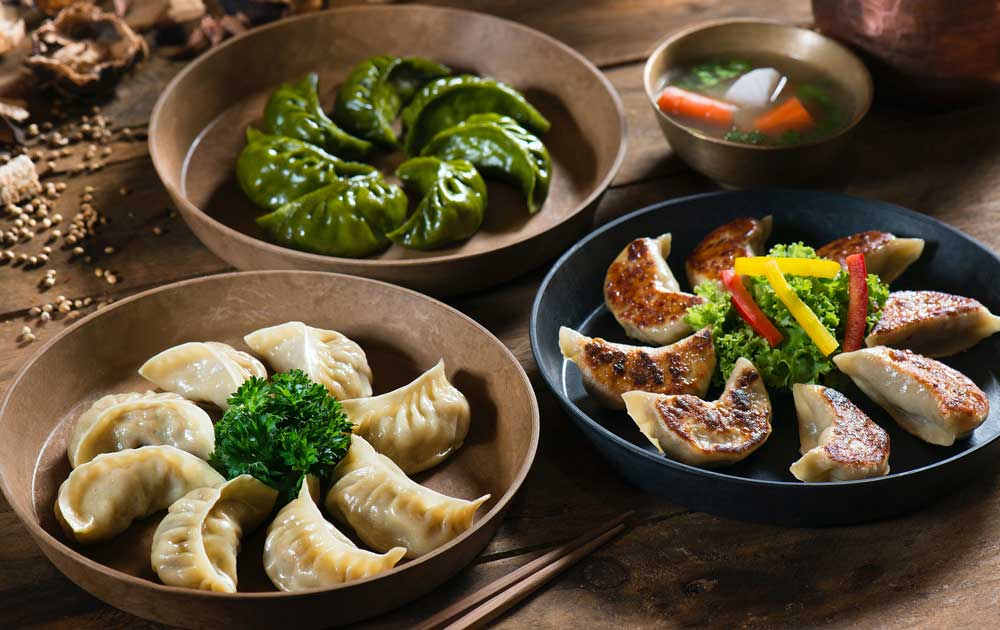 Three bowls of different coloured dumplings